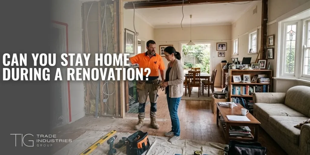 Home Extension Approval Sydney: DA, CDC or Exempt, and What Each One Means 7 Sydney homeowner talking with a tradesperson beside an opened-up wall while still living at home during a renovation